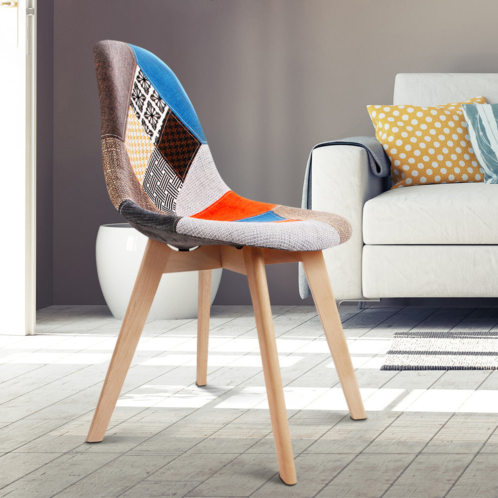 Retro dining chair with patchwork velvet upholstery in vibrant colors and light wooden legs, styled in a sunlit modern.