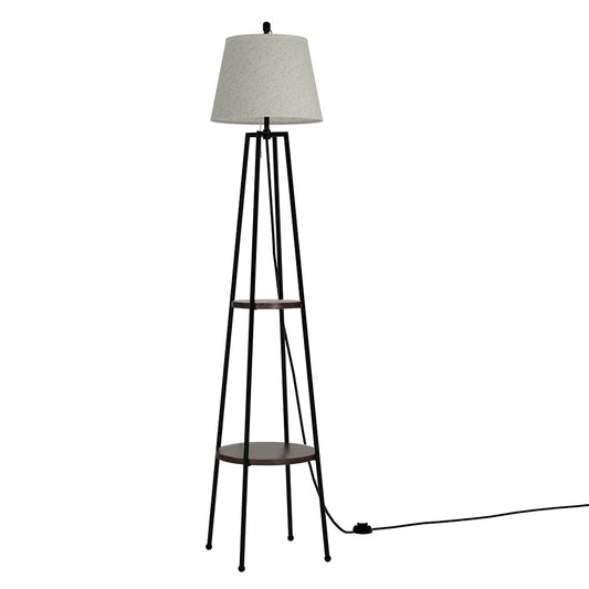 Tall retro floor lamp with black metal frame, two round wooden shelves, and a beige fabric lampshade in a minimalist living.