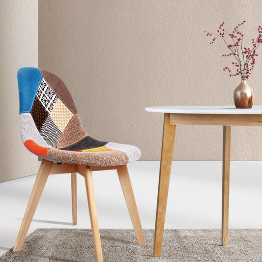 Retro velvet dining chair with patchwork upholstery and wooden legs beside a white table in minimalist home decor setting in .