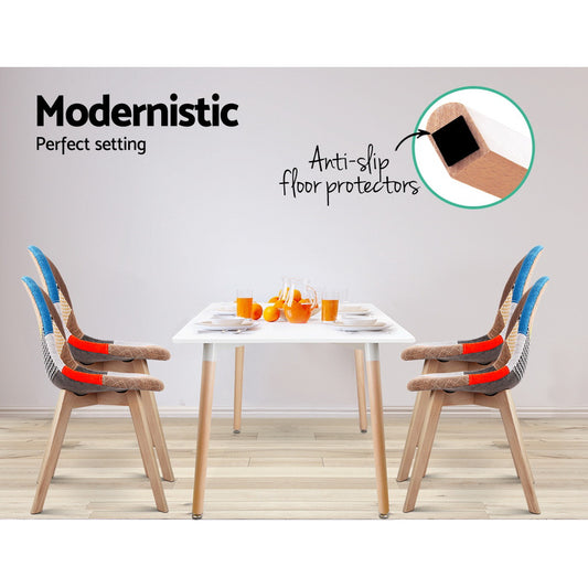 Set of four retro-style dining chairs with blue velvet seats and curved wooden legs around a white minimalist dining table.