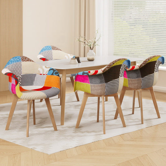 Set of four retro-style dining chairs with colorful velvet patchwork fabric and beech wood legs around a round white table.
