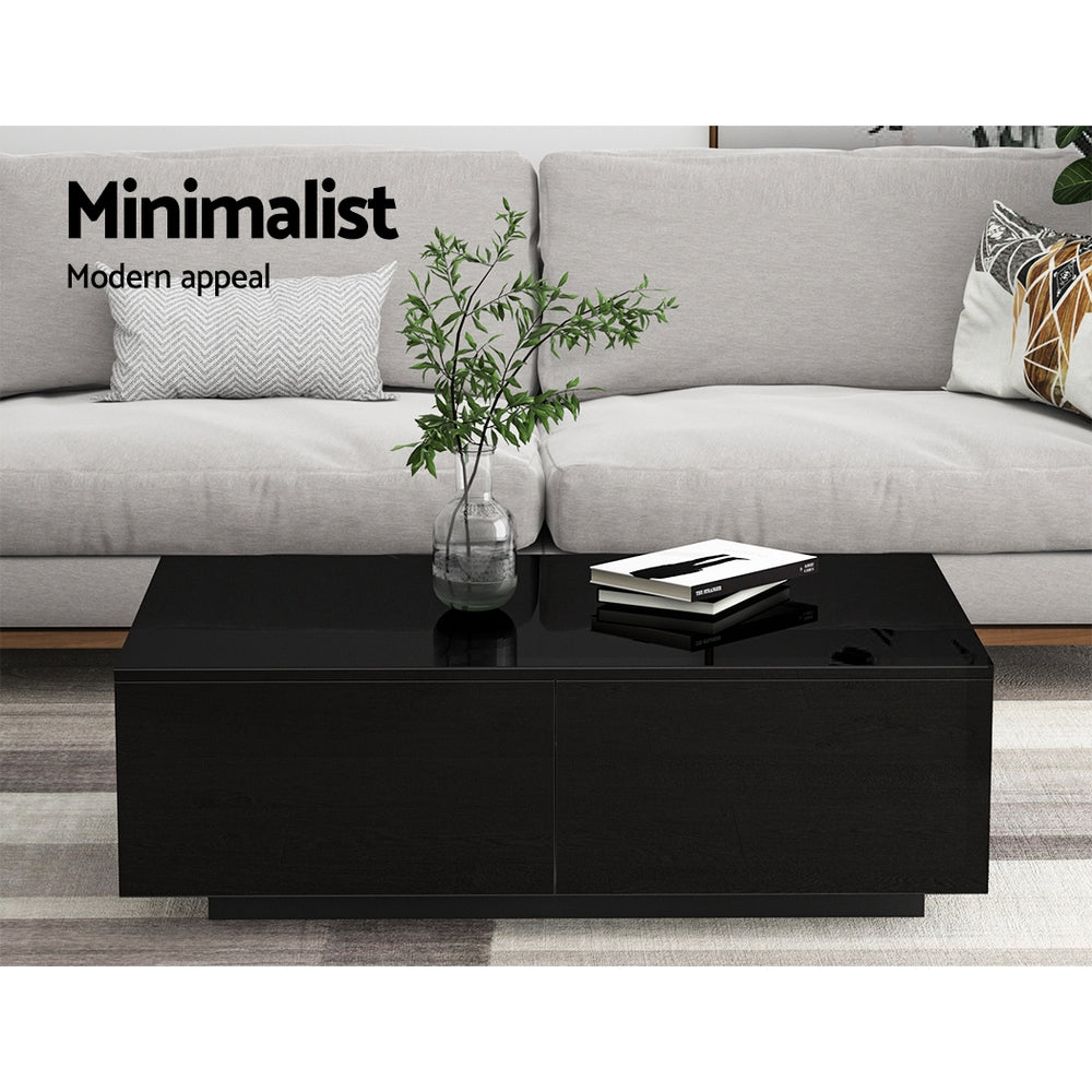 Black rectangular Artiss Coffee Table with four drawers, sleek modern design, styled with a glass vase and books on top, set .