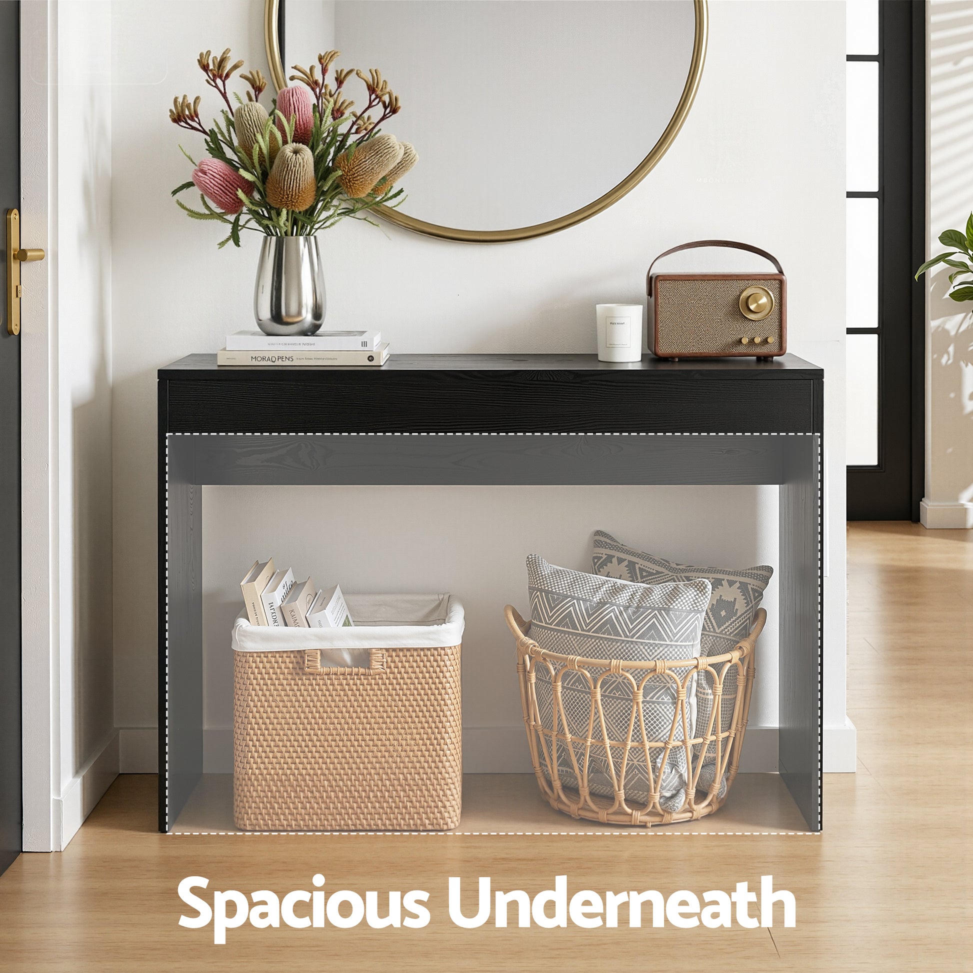 Console table with baskets underneath, flowers, and a radio on top in a room setting.