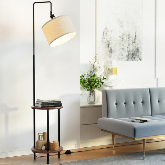 Retro-style floor lamp with beige fabric shade and two-tier black metal shelves, next to gray velvet vintage sofa in modern.