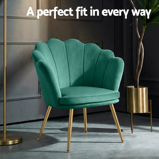 Green velvet retro armchair with scalloped backrest and gold metal legs in stylish home decor setting with dark paneled wall .