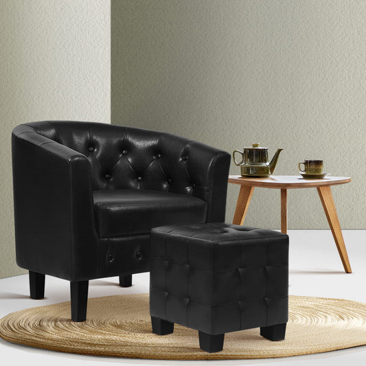 Black leather armchair and ottoman with a small wooden table in the background.