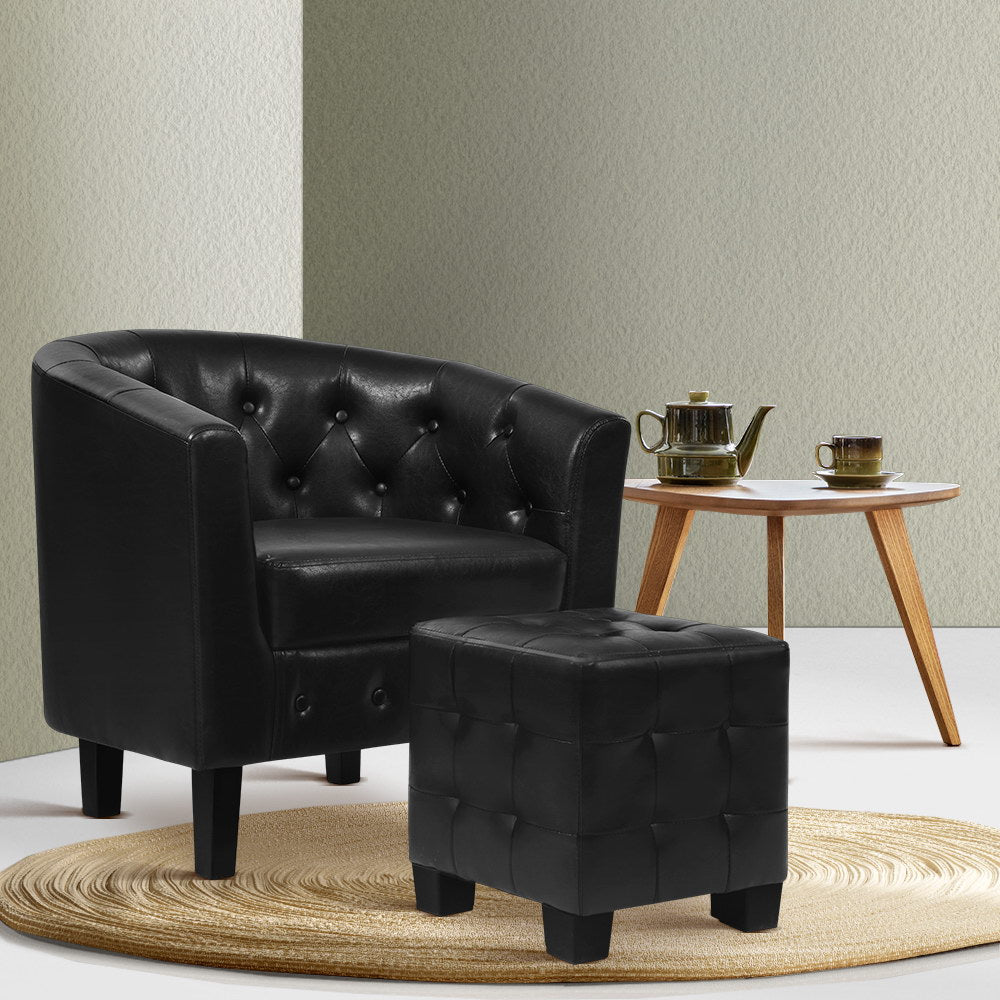 Black leather armchair and ottoman with a small wooden table in the background.