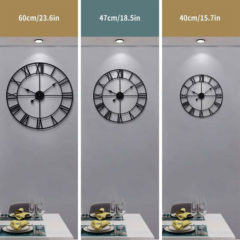 Three sizes of black wall clocks on a gray wall with dining table setup below.