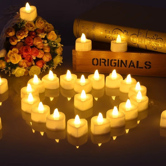 Heart-shaped LED tea lights arranged on a reflective surface with warm vintage glow, next to retro books and a.