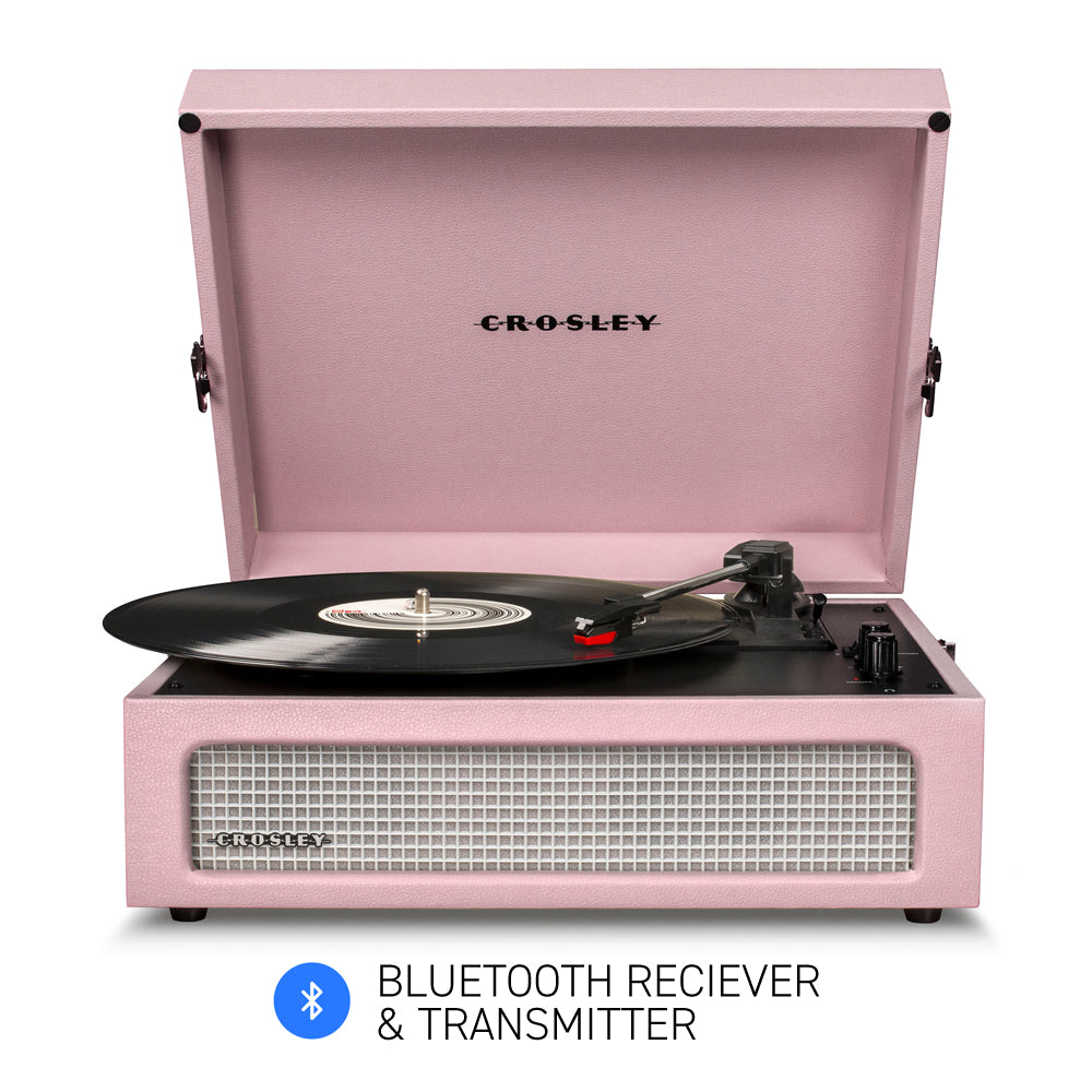 Pink Crosley record player with Bluetooth receiver and transmitter on a white background
