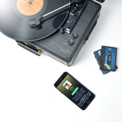 Retro black velvet suitcase turntable with record playing, vintage cassette tapes nearby, smartphone showing music app on.