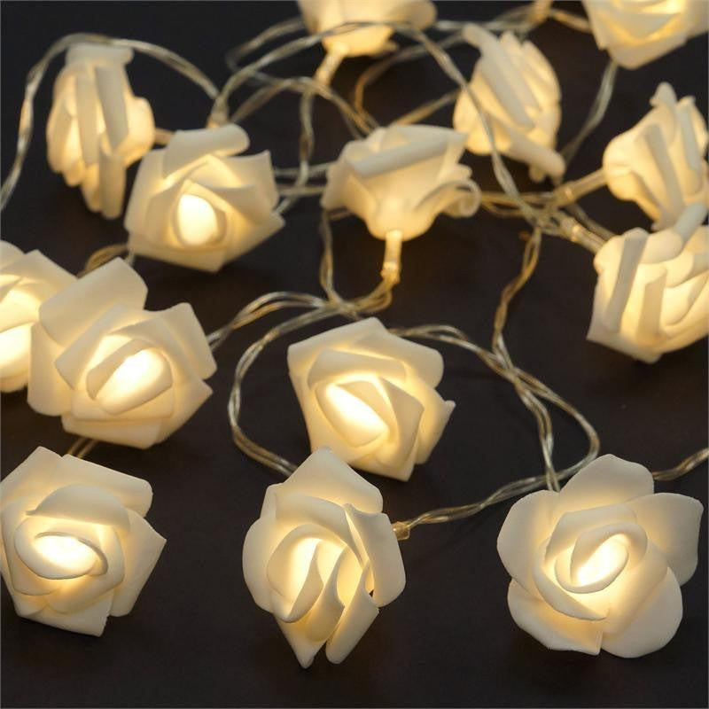 50 soft white velvet rose-shaped fairy lights glowing warmly on a delicate clear wire, ideal for vintage-inspired home decor .