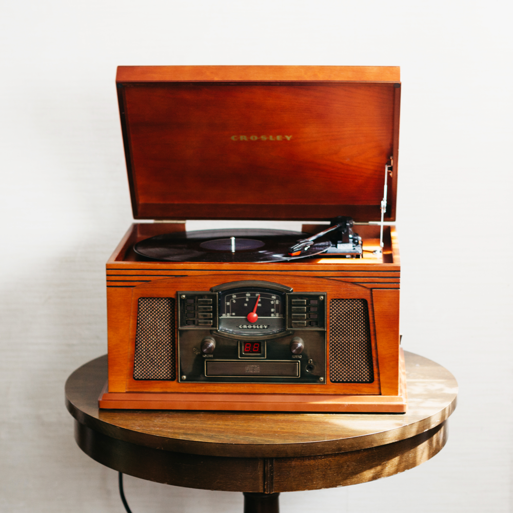 "Crosley Lancaster Bluetooth turntable in paprika open on round wooden table"