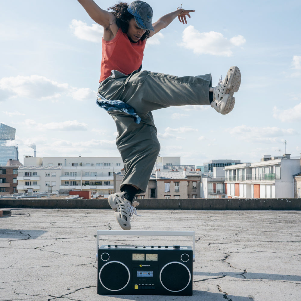 Black retro-style We Are Rewind Getto Blaster cassette player with vintage design on rooftop under blue sky, urban Australia .